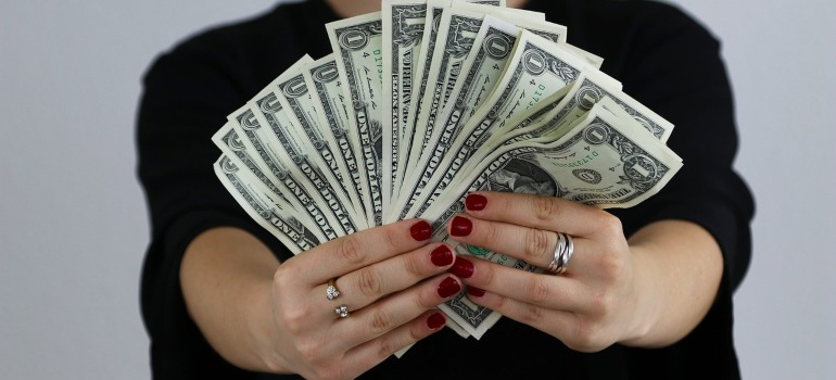 A woman holding many dollar bills.