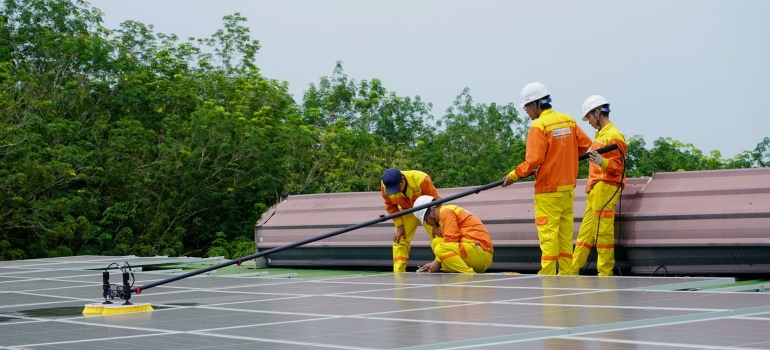 A group of people cleaning solar panels