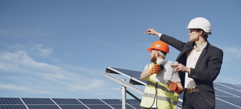 A contractor and a technician inspecting solar panels