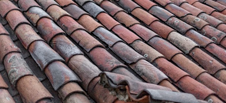 tile roof with visible degradation before renting a pressure washer