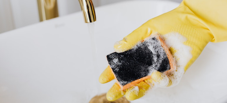 Person with a glove holding a sponge 