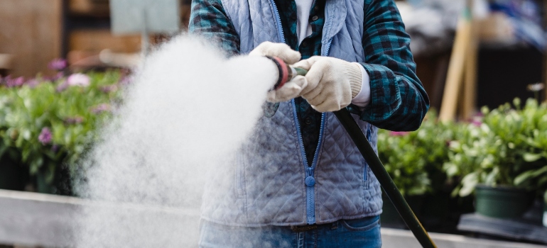 a person using pressure washing to remove bird poop stains from concrete