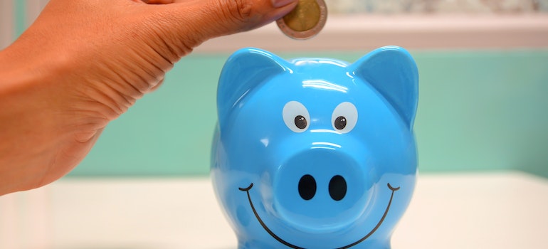 A person putting coin in a piggy bank