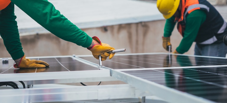 Two workers installing solar panel 