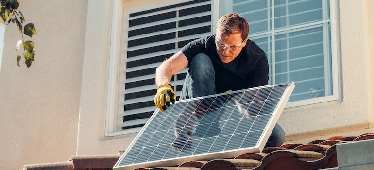 Man installing a panel carefully after learning how sensitive solar panels really are