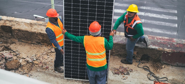 intallers carrying a solar panel