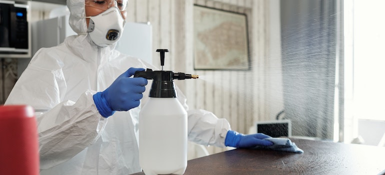 A person spraying disinfectant 