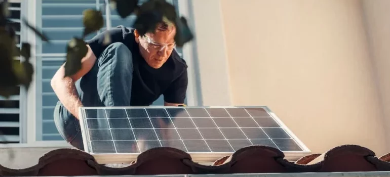 A man installing a solar panel on the roof