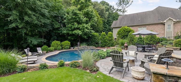 A pool and outdoor furniture in a backyard